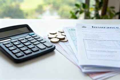 Calculatrice, pièces et contrats d'assurance sur un bureau